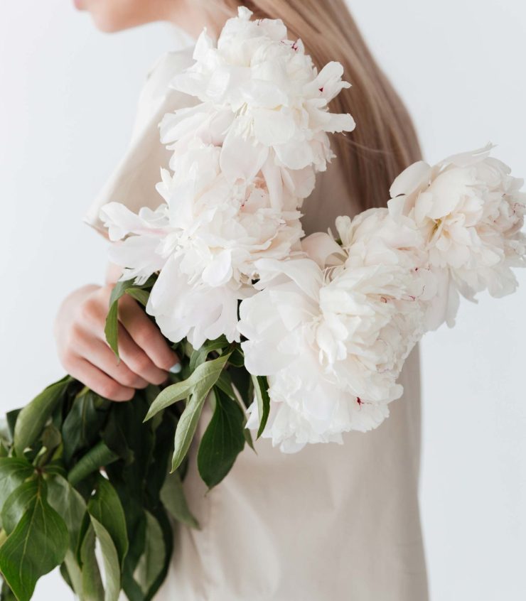 blonde-woman-standing-isolated-holding-flowers-P8B3XEP-1-scaled.jpg