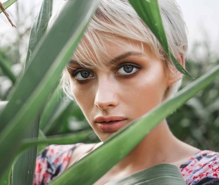 girl-between-green-leaves-in-a-corn-field-PYWBG9G.jpg